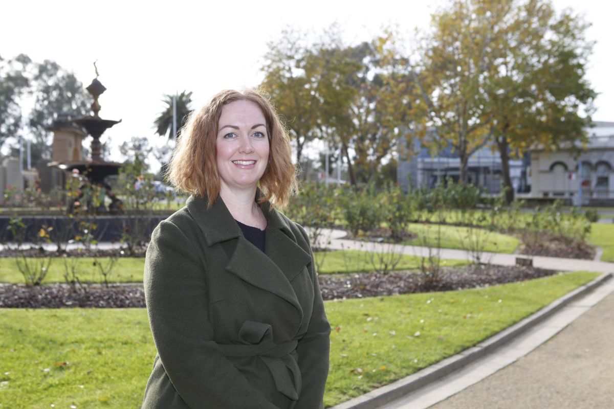 Woman standing in Victory Memorial Gardens with Council Chambers in background