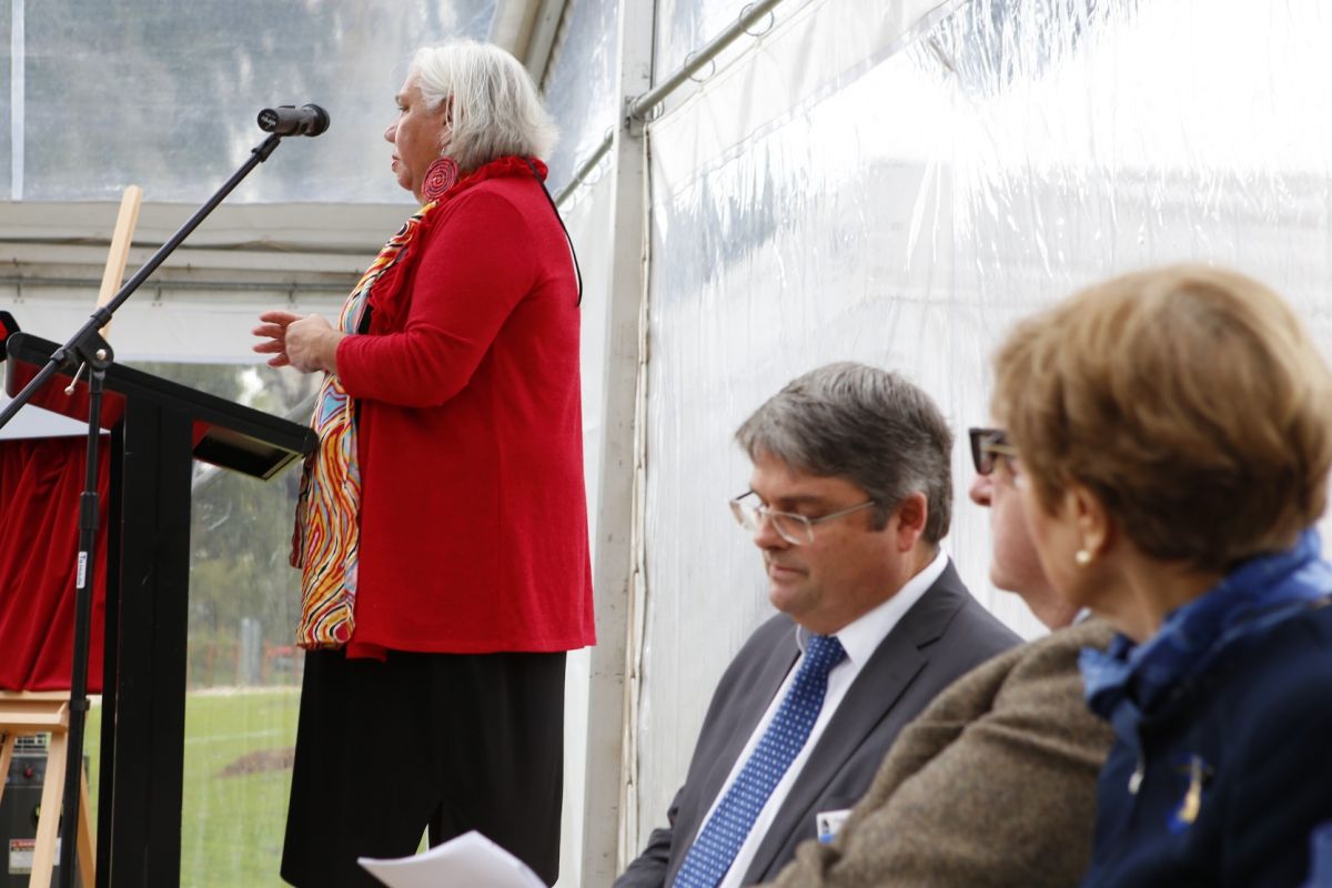 Wiradjuri Elder stands at lectern to give Welcome to Country