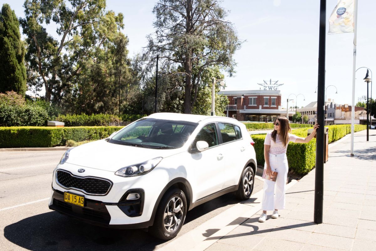 Woman standing beside car parked in Baylis Street