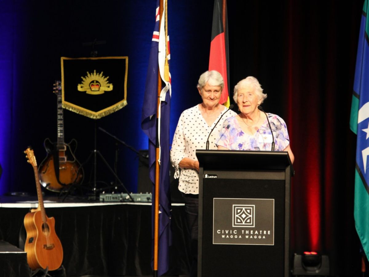 A senior woman speaks at a lectern