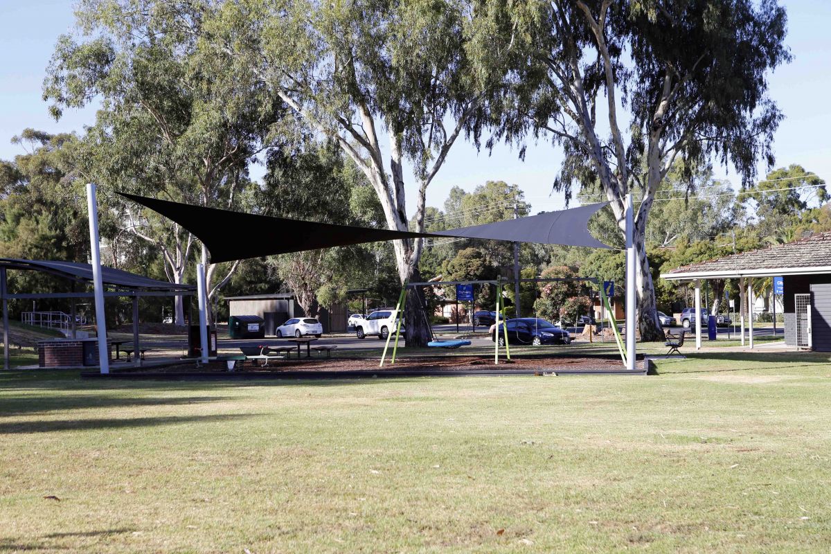 Car park with Visitor Information Centre, shared path and playhouse in background